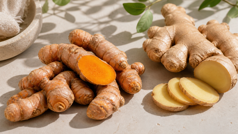 A close-up shot of fresh turmeric roots and sliced ginger on a light-colored, minimalist stone surface under natural sunlight, clean and organic aesthetic.